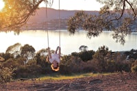 a woman swinging on a swing in a park